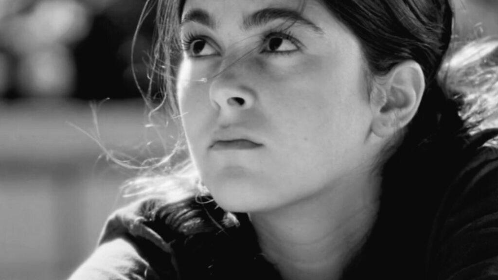 Young woman looking upward, black and white, cemetery setting
